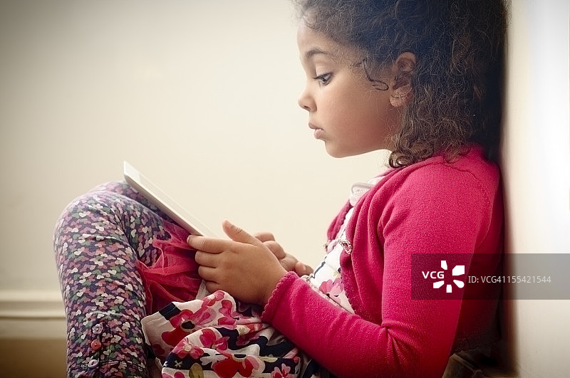 5-6岁的孩子在家用数码绘图平板电脑阅读图片素材