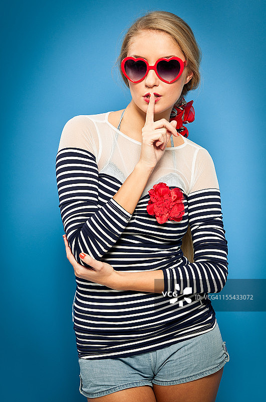 招贴女郎，水手服，心形太阳镜，手指放在嘴唇上图片素材