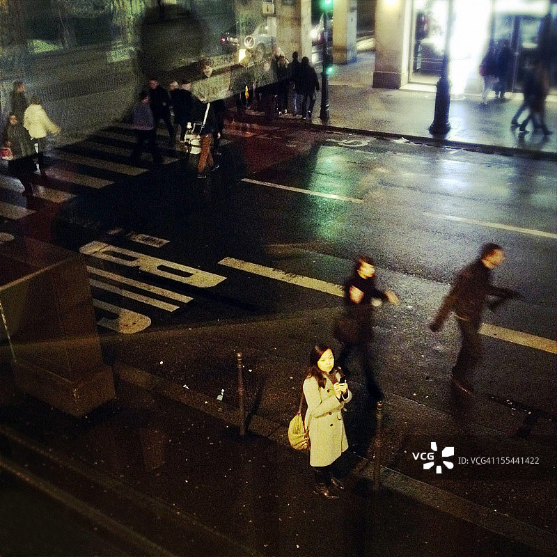 在巴黎街头手持手机的亚洲女性图片素材