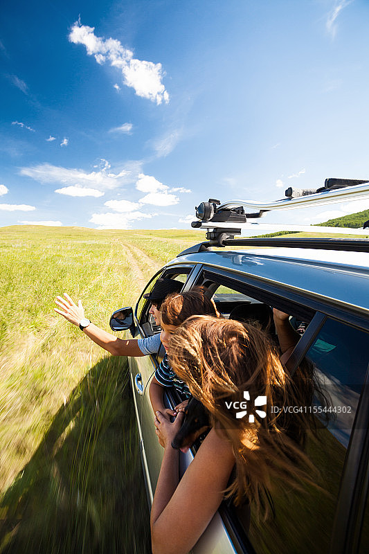 在田野里开车的年轻家庭图片素材