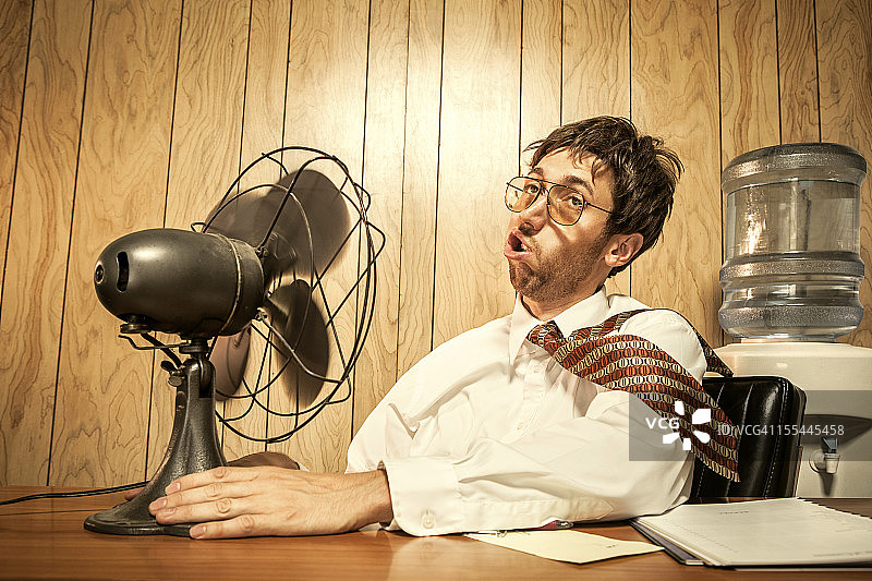 在办公室使用风扇的商人图片素材
