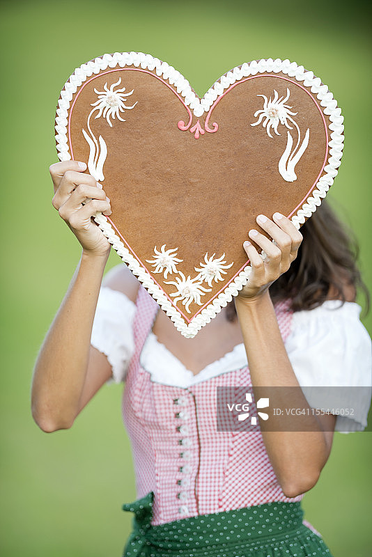 手持姜饼爱心饼干的女人，留有文案空间图片素材