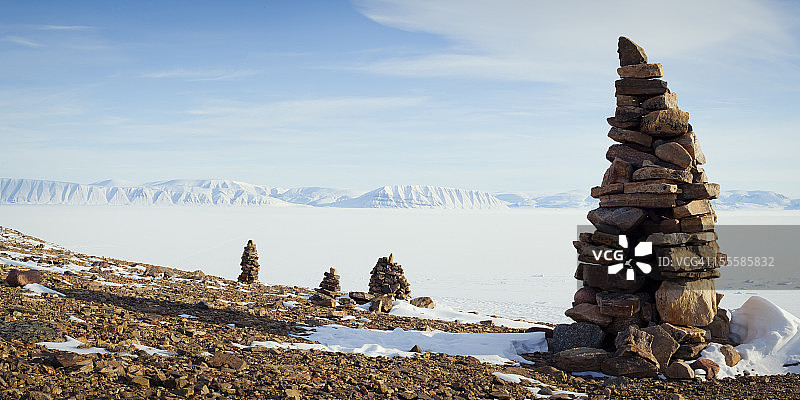 白雪皑皑的广袤区域和山脉中的岩石堆图片素材