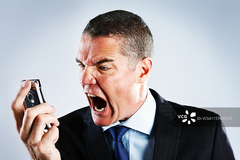 愤怒的商人对着手机大喊图片素材