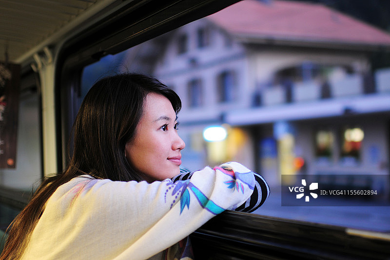 等待并透过窗户向外看的女人图片素材