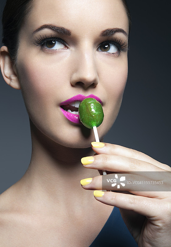 拿着棒棒糖的年轻女人肖像图片素材