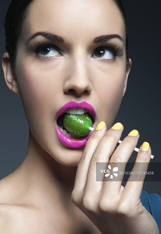 嘴里含着棒棒糖的年轻女子图片素材