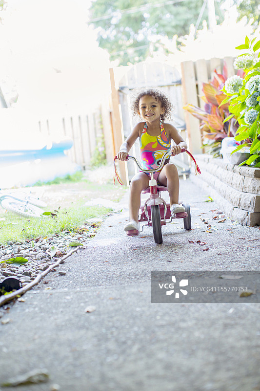 混血女孩骑三轮车图片素材