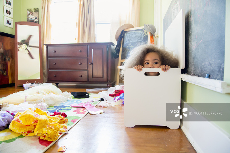 混血女孩躲在洗衣篮里图片素材