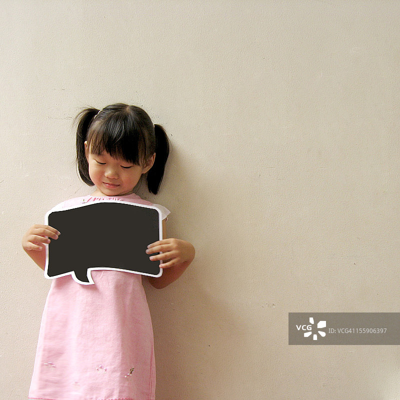 手持空白黑板的可爱小女孩图片素材