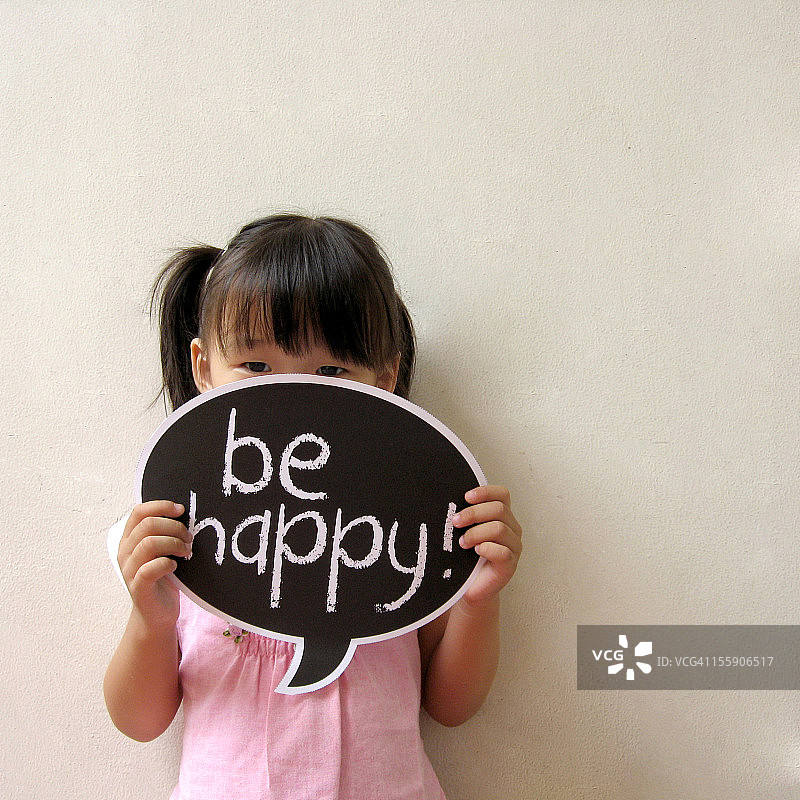 拿着“快乐”标志的小女孩图片素材