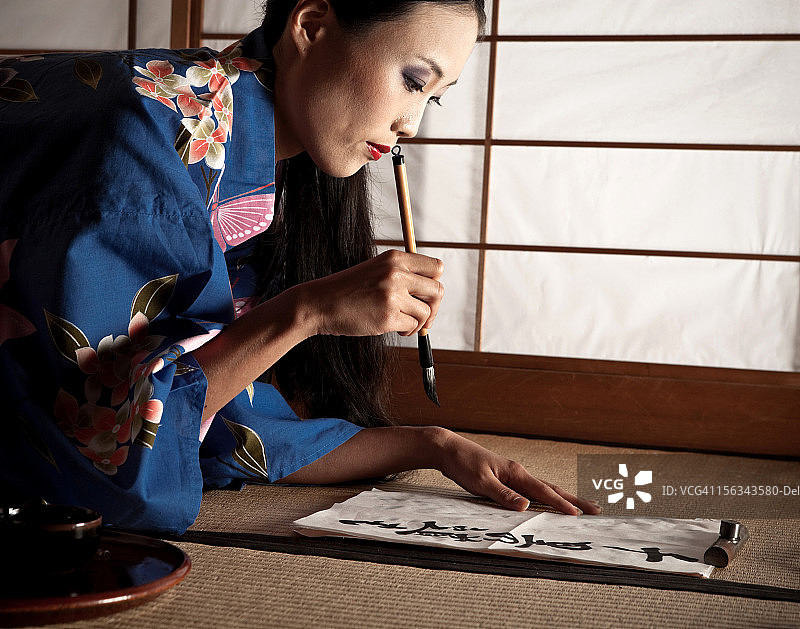 书写书法的美丽日本艺伎图片素材