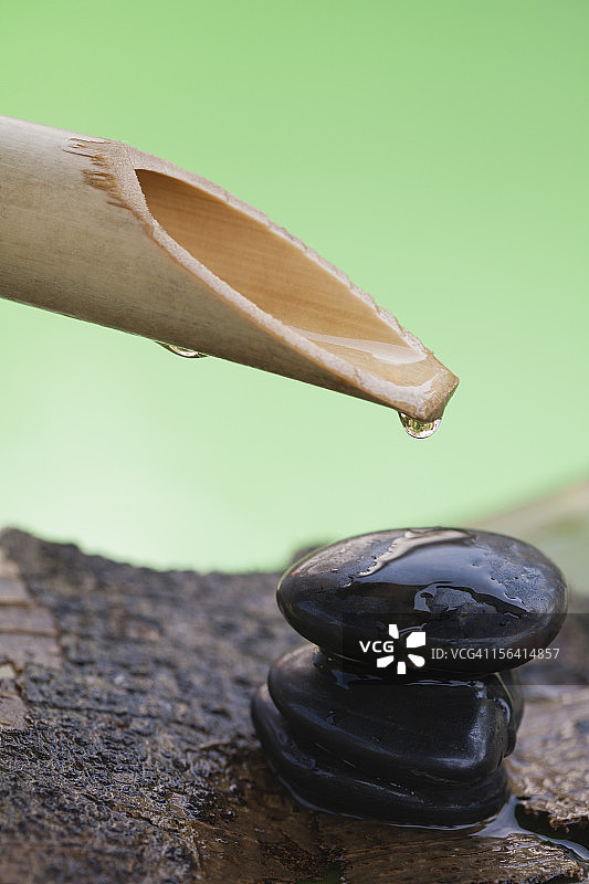 竹筒和鹅卵石上的水滴图片素材