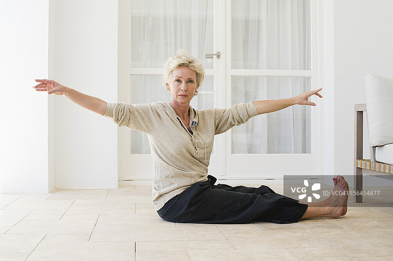 中年妇女在地板上练习瑜伽图片素材