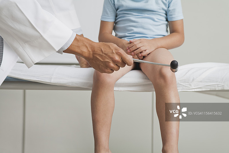 医生用反射锤检查男孩的反射图片素材