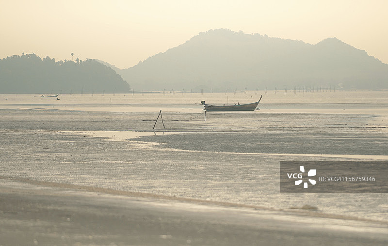 美丽海滩上的长尾船图片素材