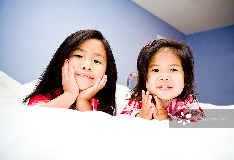 躺在床上的可爱姐妹图片素材