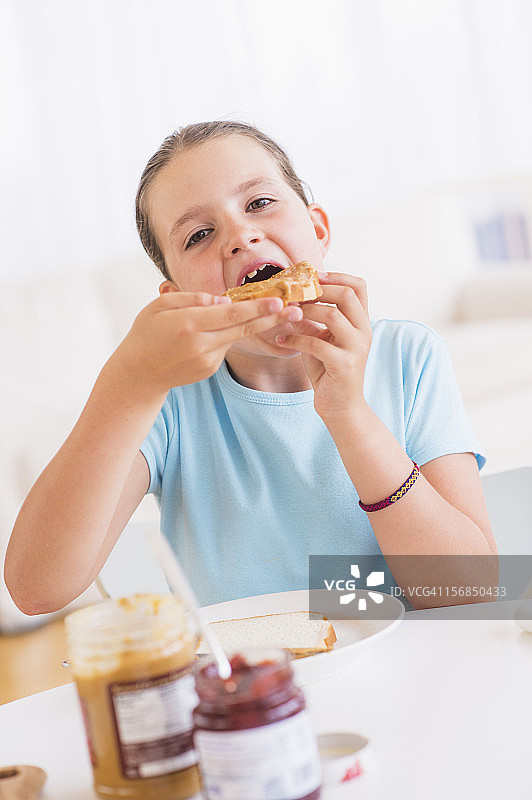 快乐的小女孩（8-9岁）正在吃早餐图片素材