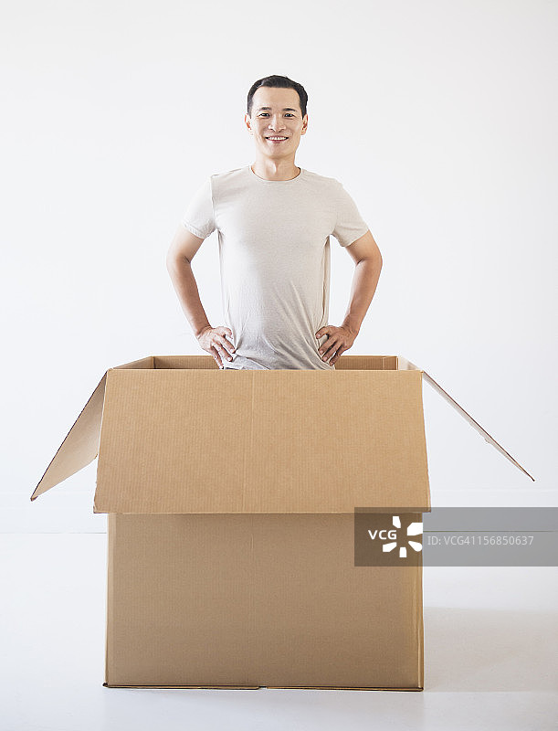 男人从纸箱里探出头图片素材