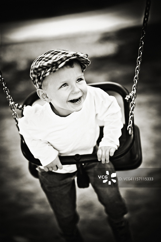 在秋千上的快乐小男孩图片素材