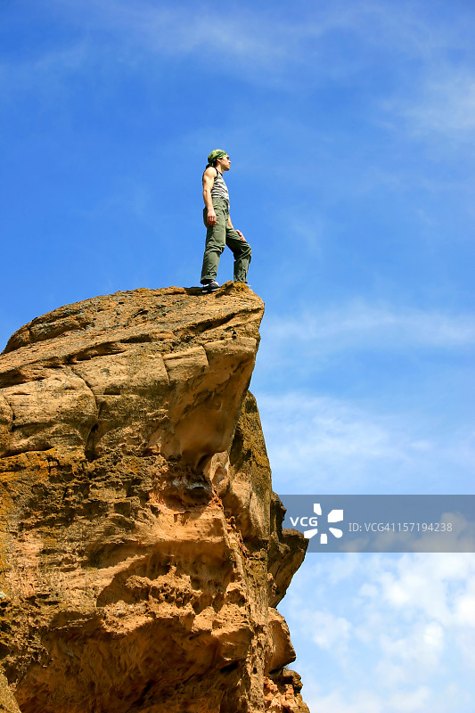 男子站在世界之巅的悬崖边图片素材