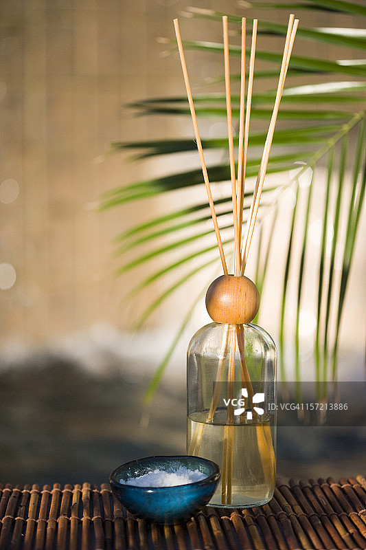 户外水疗中心的香水瓶、香薰棒和鲜花图片素材