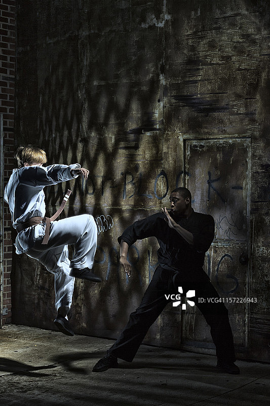 穿道服练习拳法空手道的跳跃踢腿图片素材