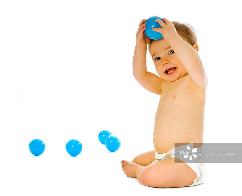 在白色背景上玩耍的穿尿布的小宝宝图片素材
