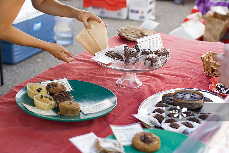 在慈善义卖活动中提供新鲜糕点的女人图片素材