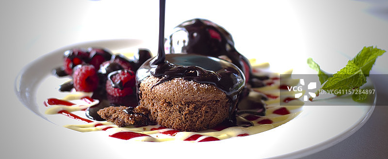 巧克力淋在巧克力舒芙蕾甜点盘上图片素材
