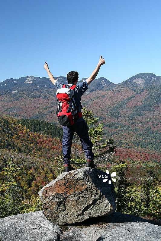 徒步登山者在山顶上竖起大拇指图片素材