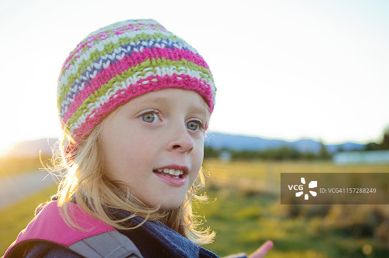 戴着冬帽在乡村散步的小女孩图片素材