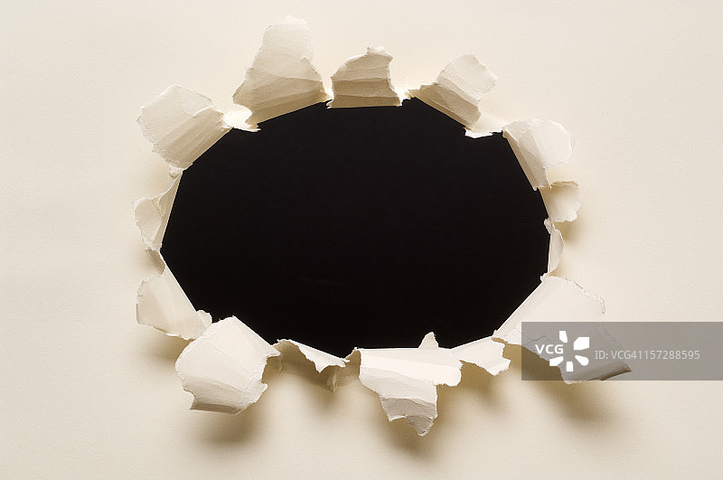 黑色背景的纸张撕裂孔洞图片素材
