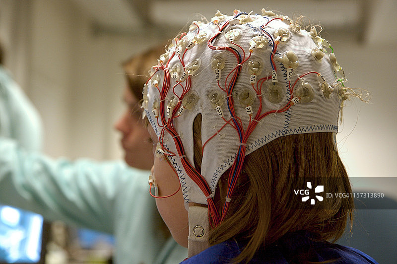 女孩连接脑电图电缆进行科学实验图片素材