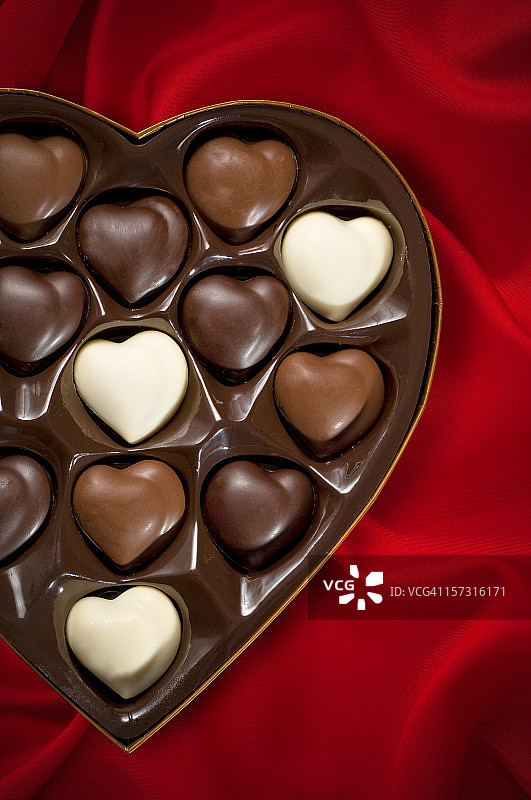 红色缎面背景上的巧克力图片素材