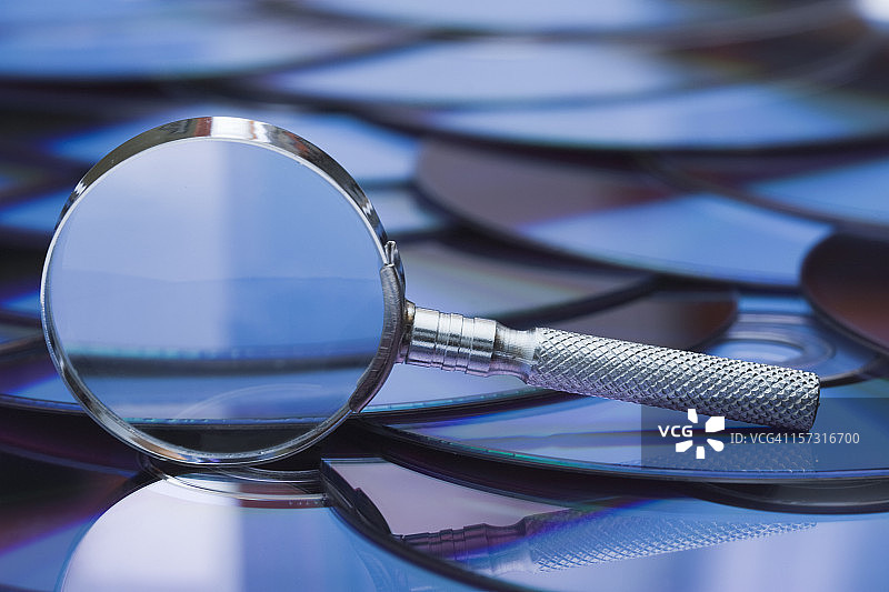 位于CD-ROM光盘上的放大镜图片素材