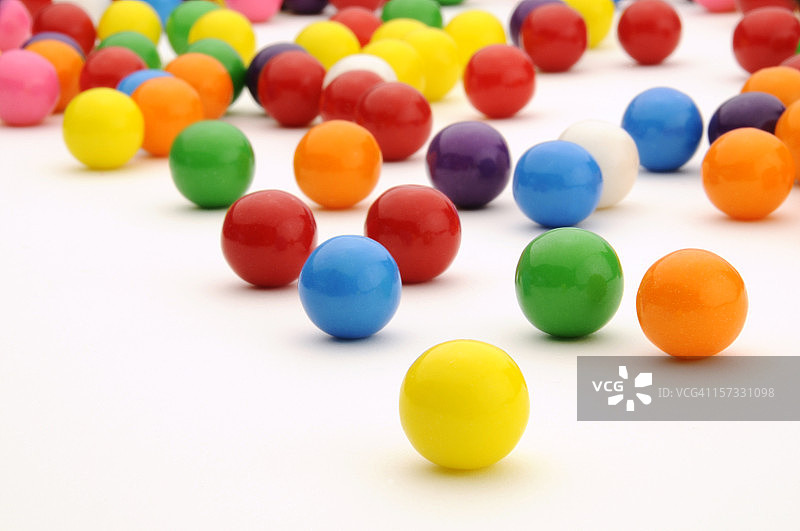 喜庆的彩色泡泡糖滚动，白色背景表面图片素材