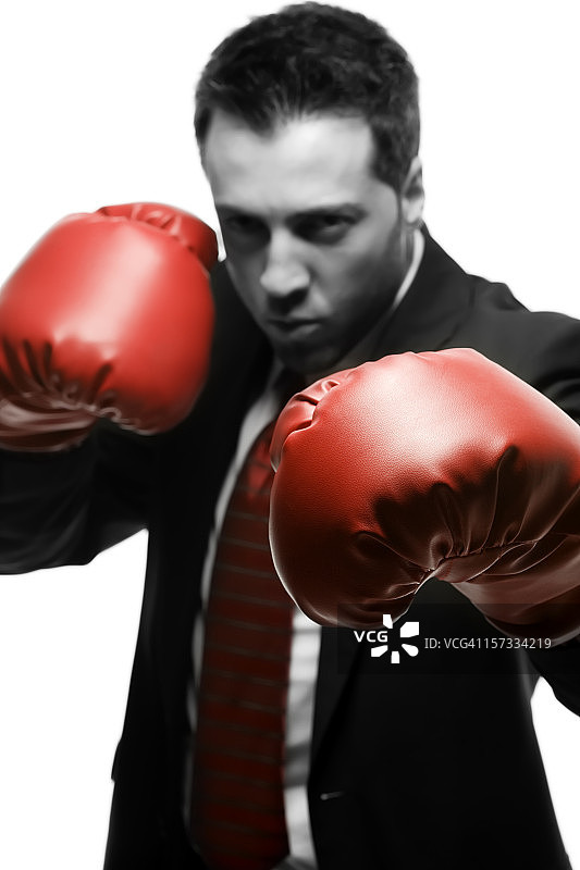 身穿深色西装、戴着红色拳击手套的商人图片素材