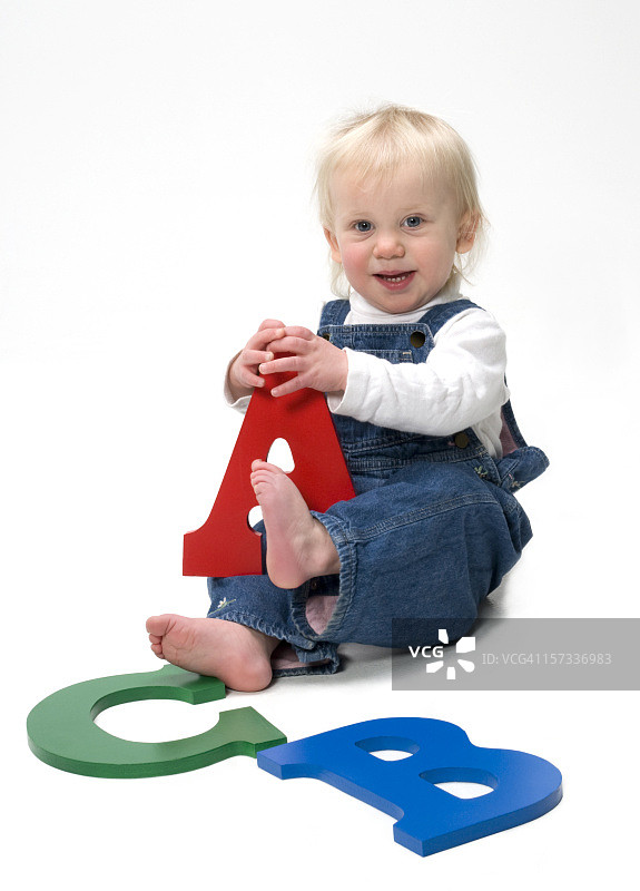 手持彩色大写字母的儿童图片素材