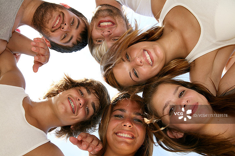 围成一圈，头靠在一起微笑的青少年图片素材