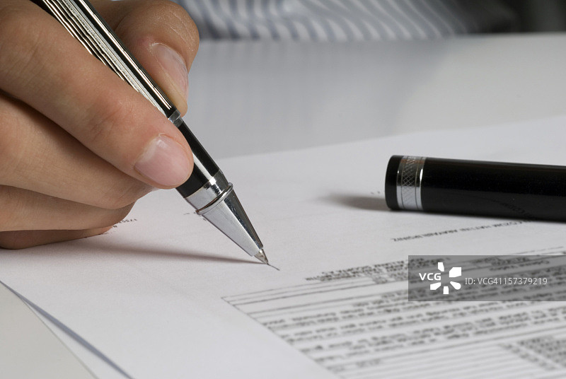 女士的手拿着笔签署文件图片素材