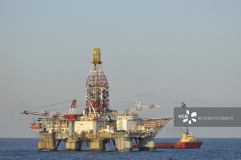 海上石油钻井平台与直升机和补给船图片素材