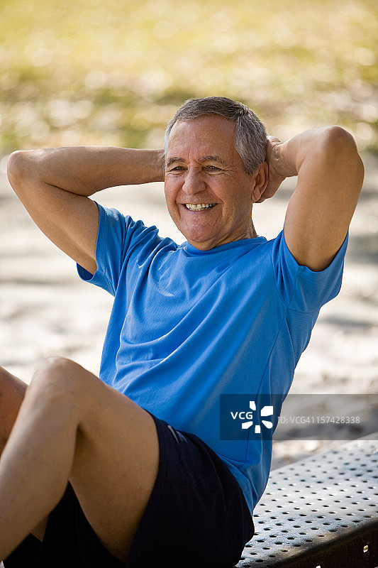 穿着运动服做仰卧起坐的老年男人图片素材