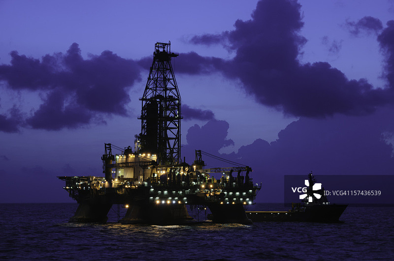 夜间海上石油钻井平台与补给船图片素材