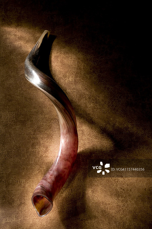 带阴影的羊角号，棕色背景和光芒图片素材