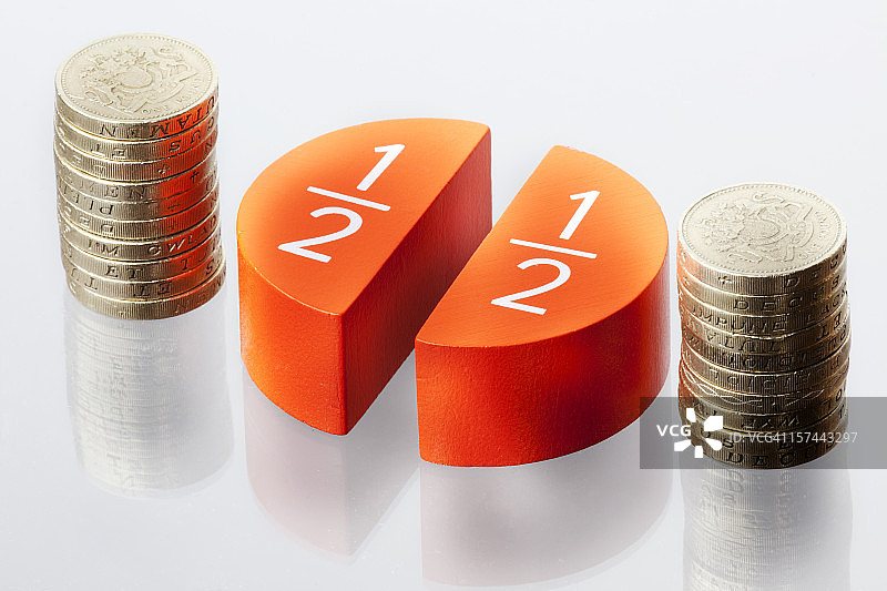 两堆硬币和表示百分之五十的圆形图图片素材