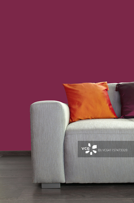 靠紫色墙壁的现代灰色材质沙发与枕头图片素材