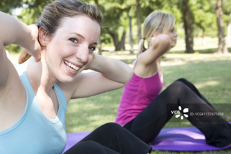 微笑的女人享受做仰卧起坐图片素材
