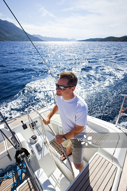 快乐的船长驾驶帆船图片素材