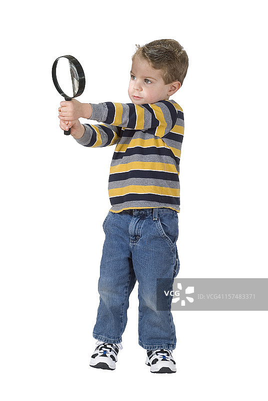 男孩用放大镜观察，面部明亮。已隔离，含裁剪路径图片素材